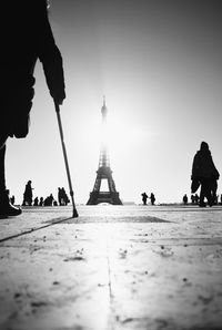 Surface level view of silhouette people with eiffel tower in background against clear sky