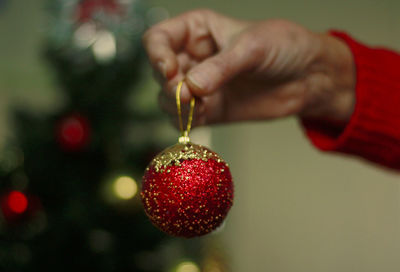 Cropped image of person celebrating christmas tree