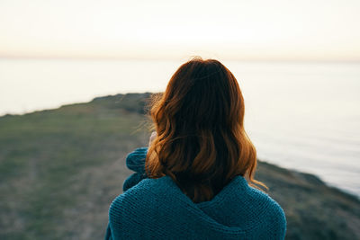 Rear view of woman looking at sea against sky