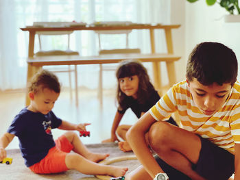 Siblings sitting in kitchen