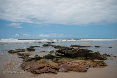 Rocks on beach against sky