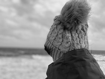 Rear view of woman looking at sea shore against sky