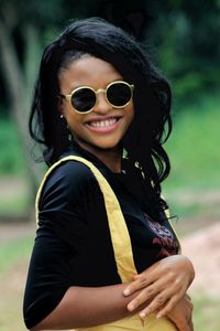 Portrait of smiling young woman wearing sunglasses outdoors