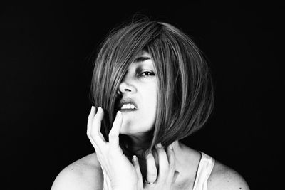 Portrait of a beautiful young woman over black background