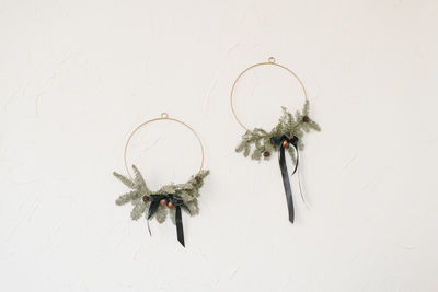 Christmas wreaths hang on a white wall