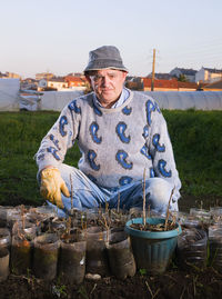 Portrait of man standing on field against sky