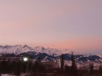 Scenic view of snowcapped mountains against sky during sunset