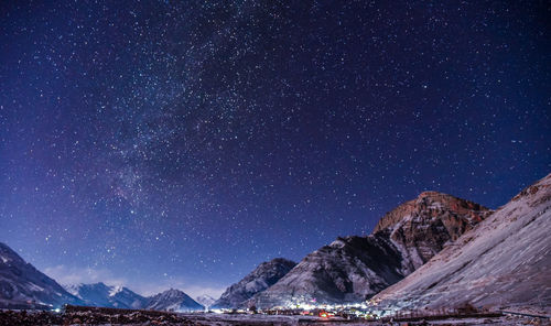 Scenic view of illuminated mountains against sky at night