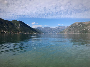 Scenic view of lake by mountains against sky