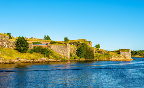 Scenic view of lake against clear blue sky
