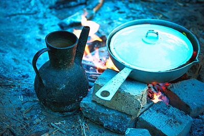 High angle view of food in cooking in pan on campfire