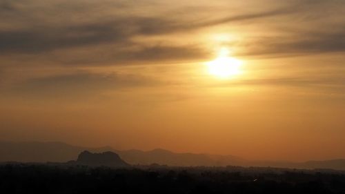 Scenic view of silhouette landscape against orange sky