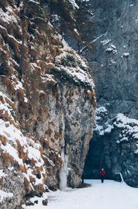 People standing on cliff by mountain during winter