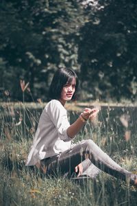 Young woman sitting on field