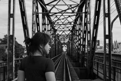 Rear view of woman standing on railway bridge