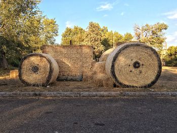 Hay bales on field against sky