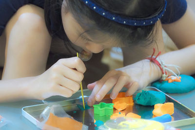 Close-up of girl crafting with clay on table
