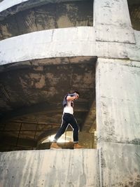 Low angle view of man walking on retaining wall in under construction building