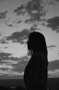 Side view of silhouette woman standing against sky