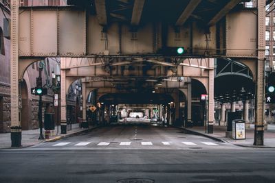 Empty road under bridge in city