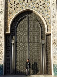 Full length of man standing against door of building