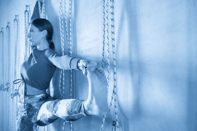 Rear view of woman standing against wall