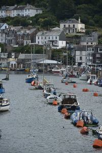 High angle view of boats moored on river by buildings in city