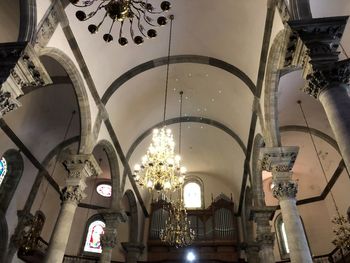 Low angle view of illuminated chandelier hanging in building