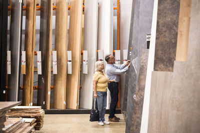 Senior male and female customer buying laminated wooden boards at hardware store