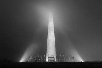 Low angle view of illuminated tower against sky at night