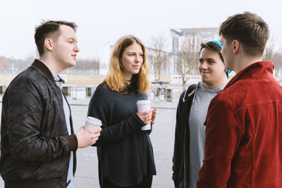 Friends talking while standing outdoors