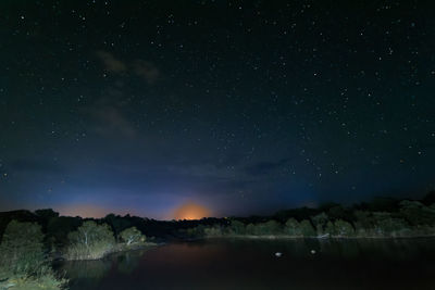 Scenic view of lake against sky at night