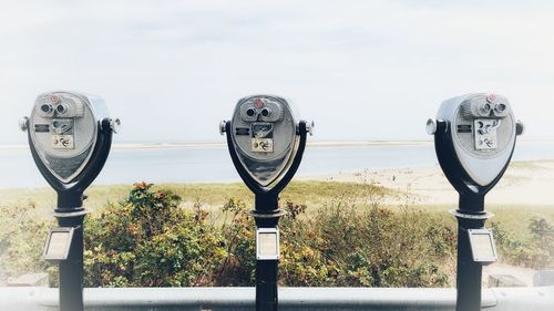 Close-up of coin-operated binoculars against sky