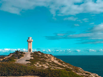 Lighthouse by sea against sky