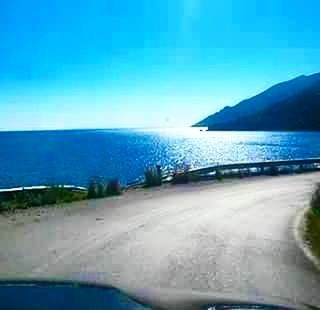 SCENIC VIEW OF SEA BY MOUNTAINS AGAINST SKY