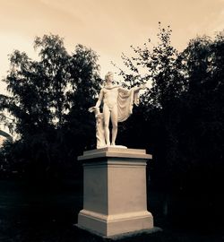 Statue in park against sky