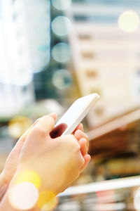 Cropped hands of woman using phone