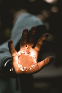 Close-up of hand holding illuminated lighting equipment