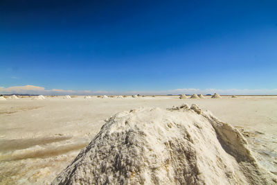 Panoramic view of desert against clear blue sky