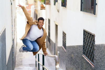 Full length of young man walking on staircase against building