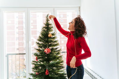 Woman holding christmas tree at home