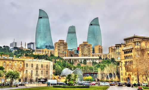 Buildings in city against cloudy sky