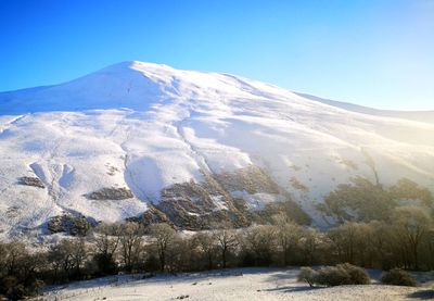 Scenic view of snowcapped mountains against clear sky