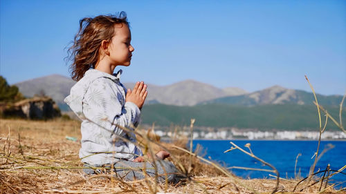 Full length of girl with arms raised against sky