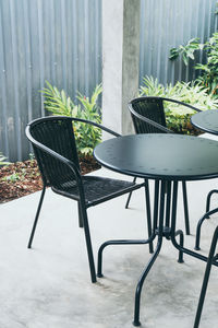 Empty chairs and table in yard