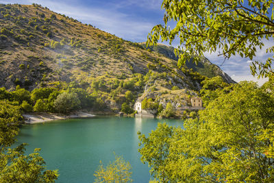 Scenic view of lake by trees against sky