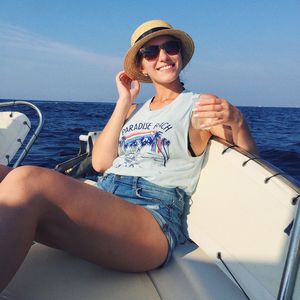 Smiling young woman sitting on boat against sky