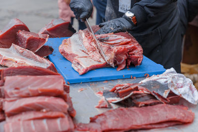 Man eating fish for sale in market