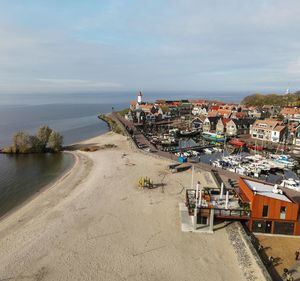 High angle view of buildings by sea against sky