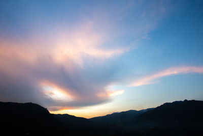 Low angle view of silhouette mountains against dramatic sky